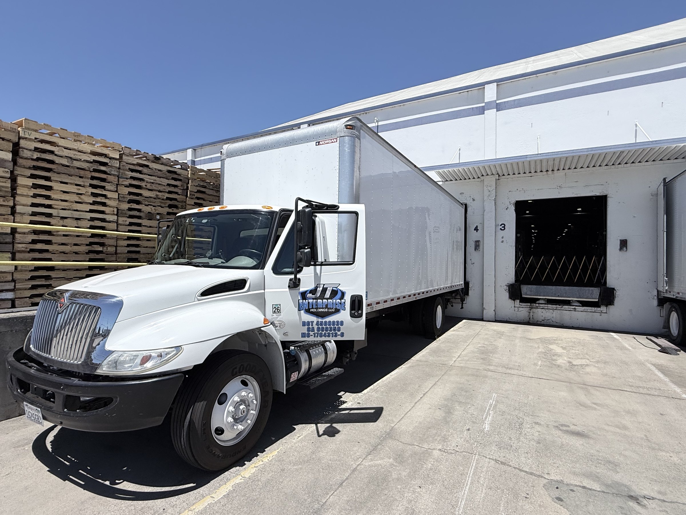 JT Enterprise white straight box truck positioned at a commercial loading dock in California